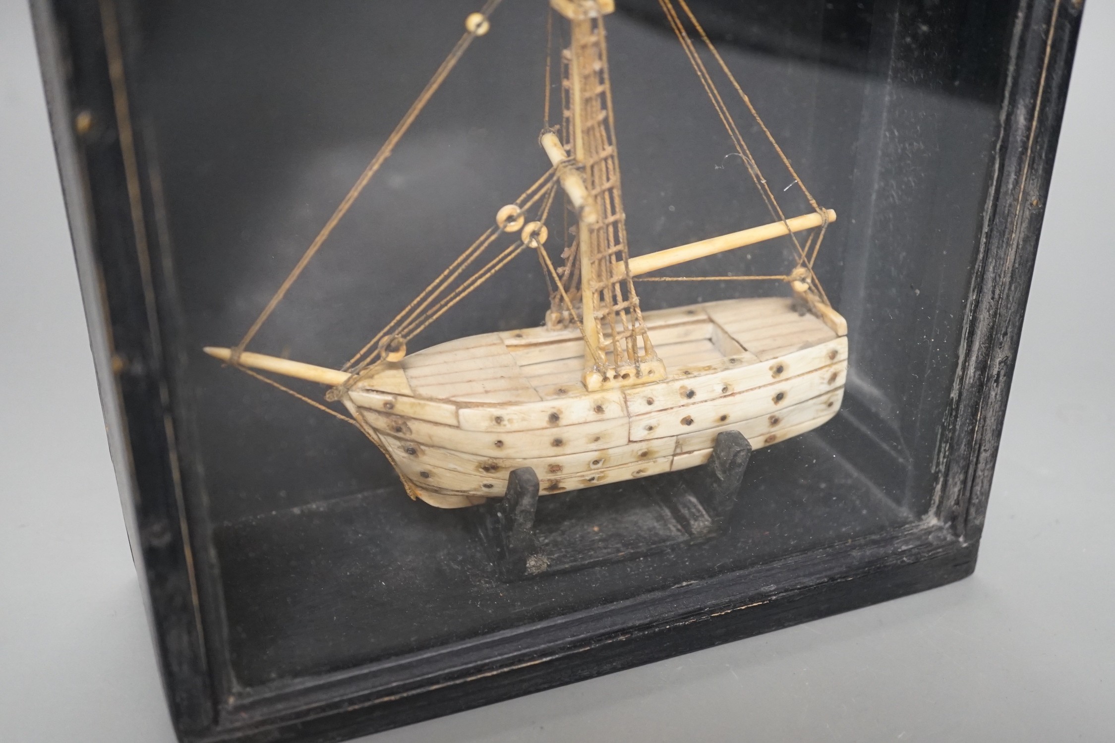 A cased bone Napoleonic style, carved prisoner-of-war ship, 18cms wide x 18.5cms high
